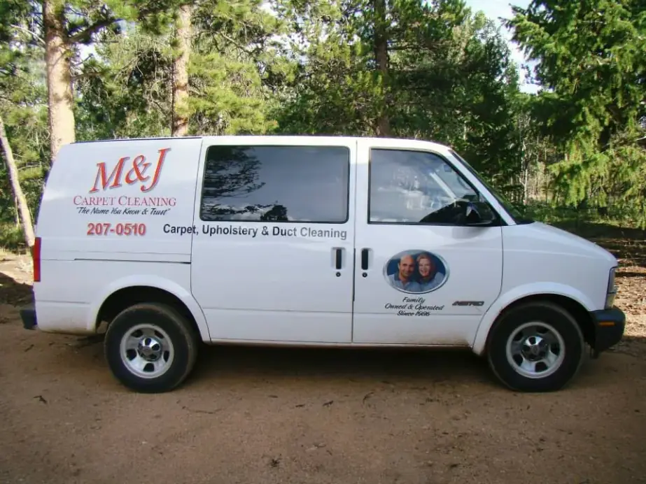 M&J’s white work van: red M&J Carpet Cleaning script, The Name You Know & Trust, 207-0510, Carpet, Upholstery & Duct Cleaning, and a family portrait oval reading Family Owned & Operated Since 1986